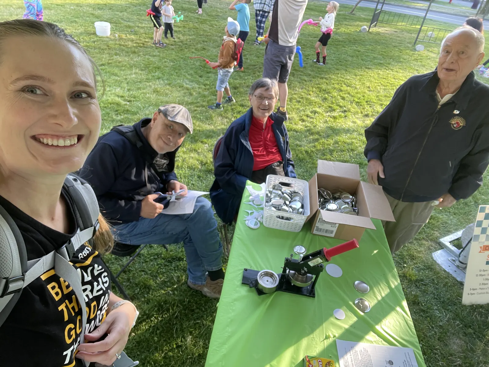 A member taking a selfie at a community event with Rotarians at a craft table