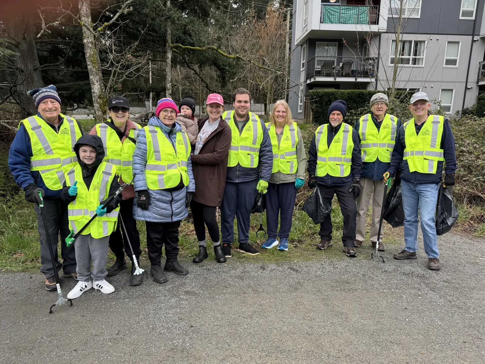 Members, friends and families in safety vests at a community cleanup